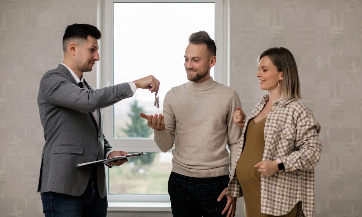 Estate agent giving house keys to couple during property handover in Annan